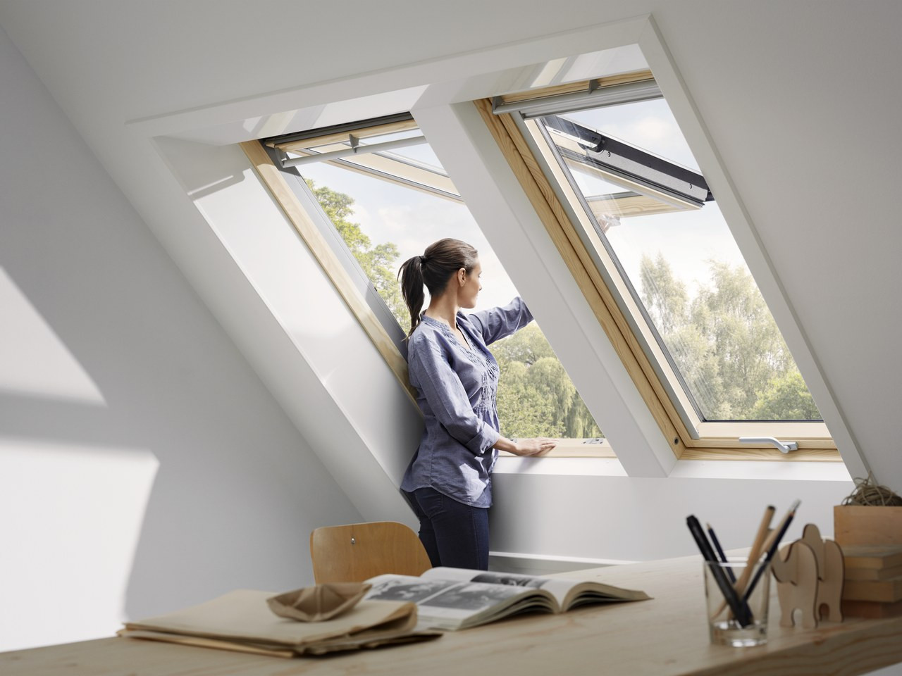 Woman looking through Velux top-hung windows